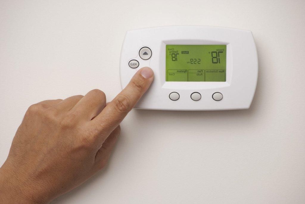 手指按下恒温器上的按钮，温度设置为78